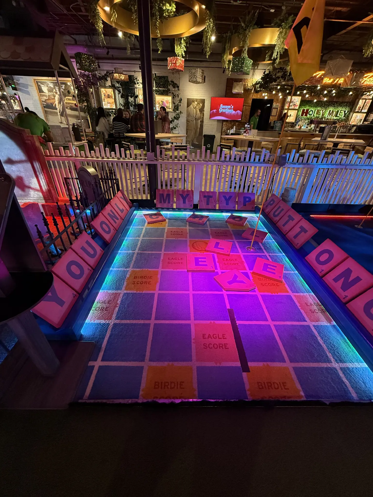 A giant scrabble board. The letters spell out “You only putt once”