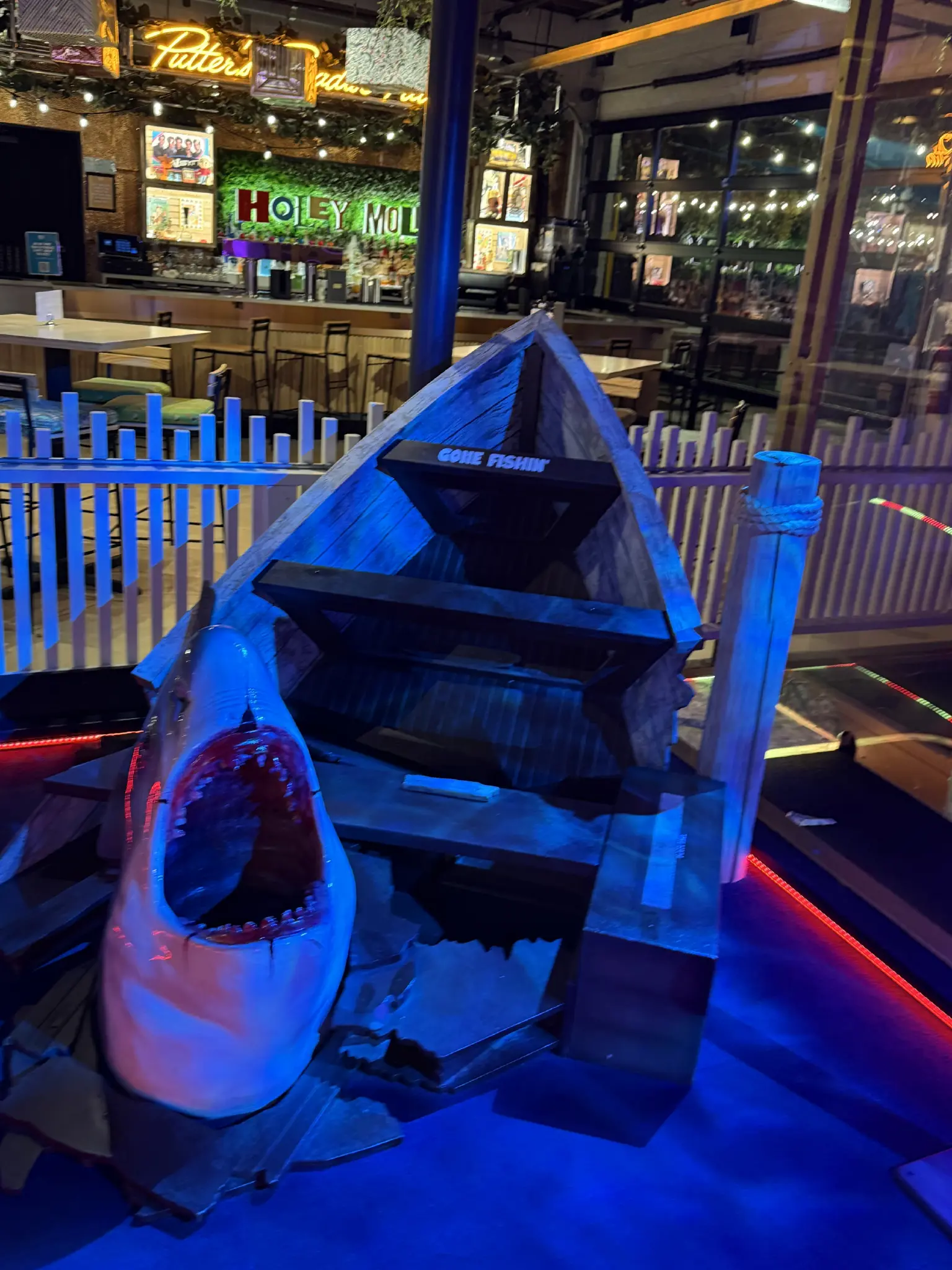 A tribute to Jaws, the movie. A half eaten boat and the head of a shark, mouth wide open showing its teeth.